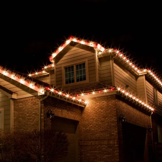 Close detail of red and warm white C9 bulbs clipped in a clean line along a gable and eave
